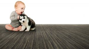 baby with puppy on natural wool carpet